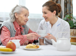 caretaker is preparing meal for her patient